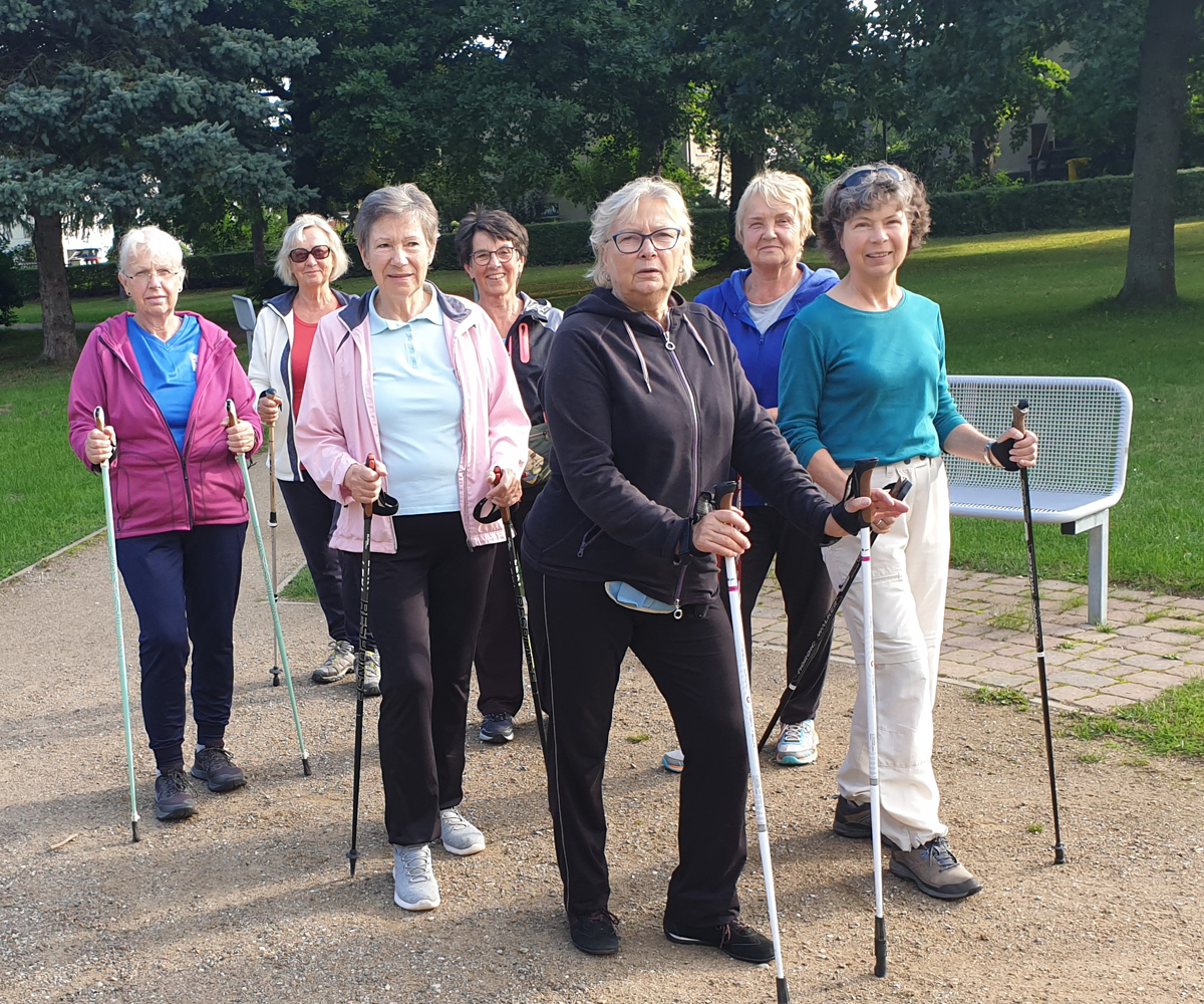 Eine Gruppe von Personen beim Nordic Walking im Park